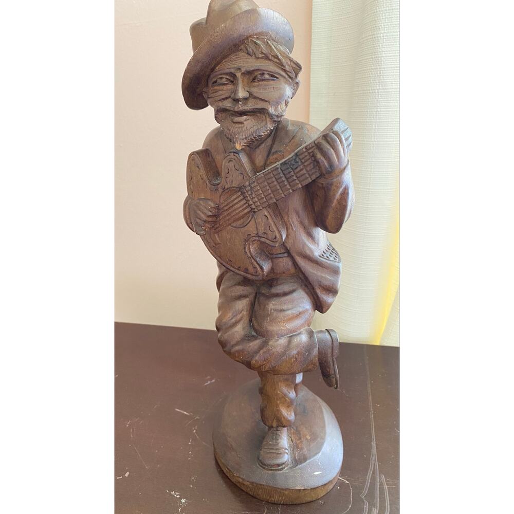 vintage folk art hand-carved wooden figure of a man playing a guitar.